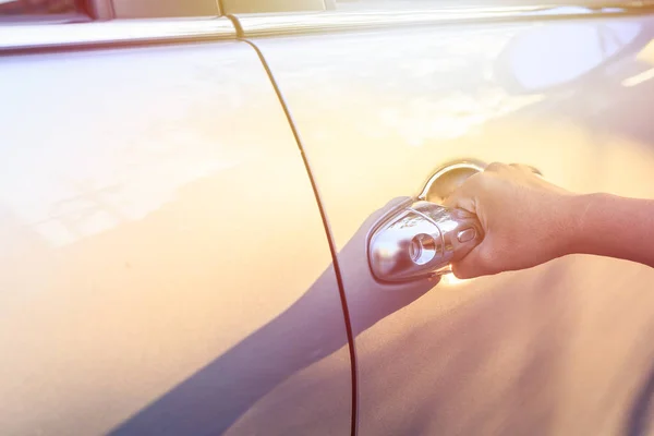 Une femme ouvre la porte de la voiture. Tourné le soir avec une fusée éclairante — Photo