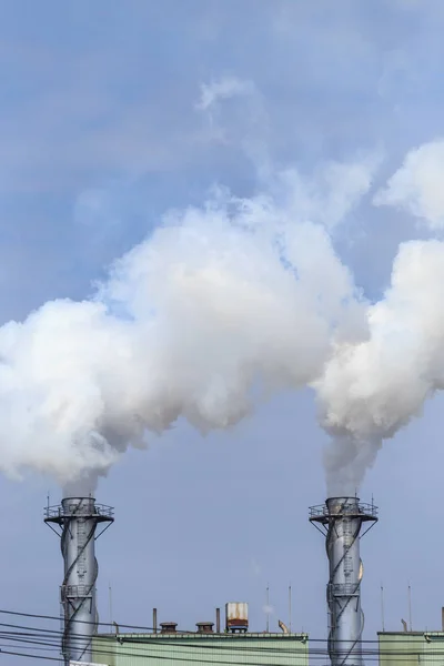 Vapeur industrielle blanche en usine sur ciel bleu — Photo