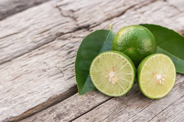 Skiva grön färsk citron på träbord bakgrund — Stockfoto