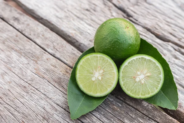 Skiva grön färsk citron på träbord bakgrund — Stockfoto