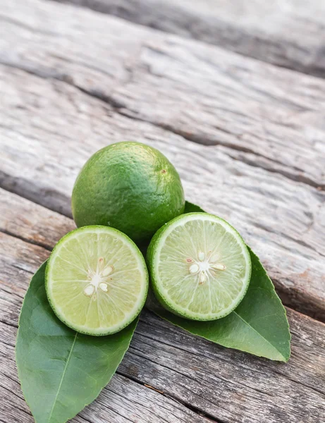 Skiva grön färsk citron på träbord bakgrund — Stockfoto