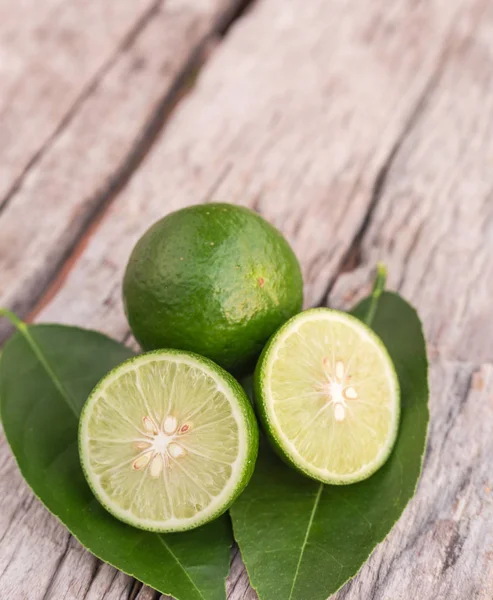 Fatia de limão fresco verde no fundo da mesa de madeira — Fotografia de Stock