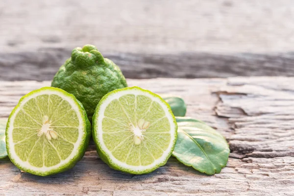 Skiva grön färsk bergamott frukt på träbord bakgrund — Stockfoto