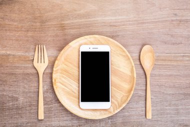 Smartphone ahşap tabak, kaşık ve çatalı ahşap tahta backgr