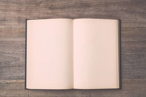 Old book on wooden plank background — Stock Photo, Image