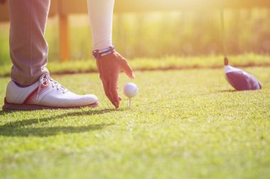 Yeşil sahası Golf oynayan bir adam. Golf topu üzerinde odaklanmak