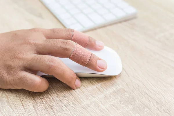 Ręka z szkody na palec za pomocą biały komputera mysz bezprzewodowa o — Zdjęcie stockowe