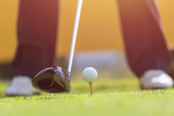 Un hombre jugando al golf en el campo verde. Enfoque en pelota de golf — Foto de Stock