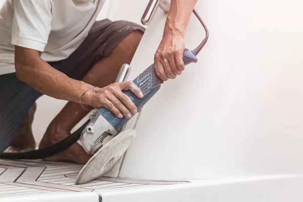 Jacht onderhoud. Een man polijsten van de kant van de witte boot in de — Stockfoto