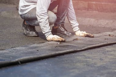 Tar folyo binanın çatısında yükleme alt grup. 