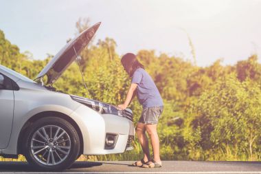 Smartphone kırık arabası önünde yolda kullanan kadın. C