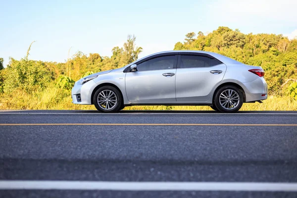 PHUKET, TAILANDIA - 16 de junio: Toyota Corolla Altis estacionando en la carretera de asfalto en Phuket el 16 de junio de 2017. El distribuidor oficial de Toyota, que es la parte superior del mercado para el coche comercial . —  Fotos de Stock