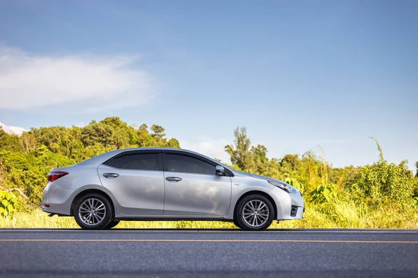 PHUKET, TAILANDIA - 16 de junio: Toyota Corolla Altis estacionando en la carretera de asfalto en Phuket el 16 de junio de 2017. El distribuidor oficial de Toyota, que es la parte superior del mercado para el coche comercial . — Foto de Stock