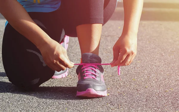 Vrouw koppelverkoop sport haar schoen. Voorbereiden voor uitvoeren in het park — Stockfoto