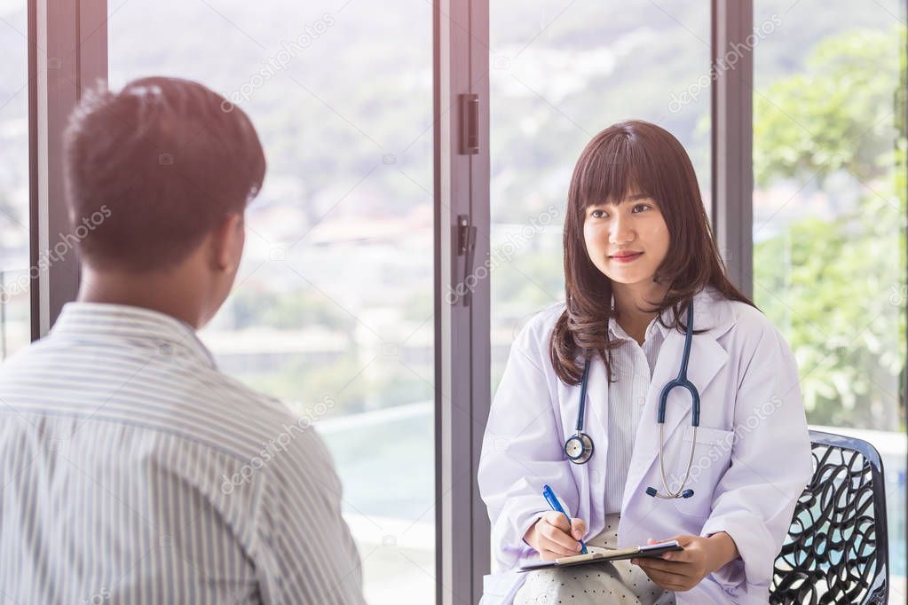 Female doctor discussing with her male patient beside the window