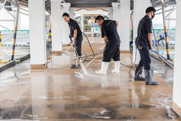 PHUKET, TAILANDIA - 21 DE JULIO: Una gente no identificada limpia la pasarela exterior del lavado de arena usando una lavadora de alta presión de agua a chorro y una máquina de pulido el 21 de julio de 2017 en Phuket, Tailandia . —  Fotos de Stock