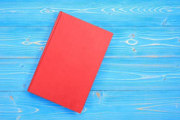 Old red book on wooden plank background. Blank empty cover for d — Stock Photo, Image