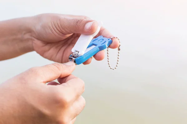 Mujer cortándose las uñas usando cortauñas — Foto de Stock