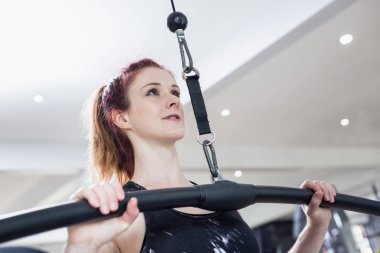 Beyaz kadın egzersiz donanımları ile egzersiz yaparak ve