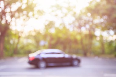 Araba park alanı tarafından ağaç parkı çevreleyen kamu