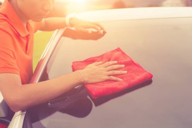 Genç adam yeni gümüş vücut temizliği kırmızı mikrofiber bez kullanarak