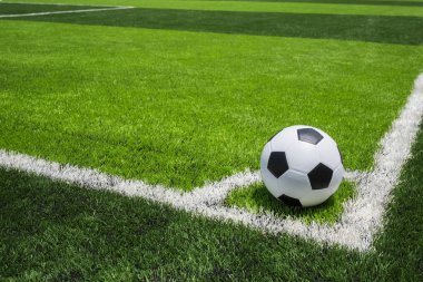 Futbol topu kamu, yapay parlak ve koyu yeşil çimenlerin üzerinde 