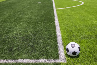 Futbol topu kamu, yapay parlak ve koyu yeşil çimenlerin üzerinde 