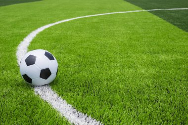 Futbol topu kamu, yapay parlak ve koyu yeşil çimenlerin üzerinde 