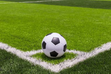 Futbol topu kamu, yapay parlak ve koyu yeşil çimenlerin üzerinde 