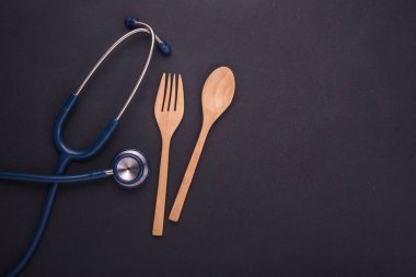 Doktor stetoskop ve kaşık, çatal ve ahşap tabak o mavi
