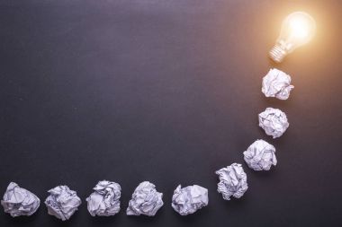 Üstten Görünüm kağıt ve ampulleri siyah taş tahta üzerinde buruşuk. CR