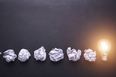 Üstten Görünüm kağıt ve ampulleri siyah taş tahta üzerinde buruşuk. CR