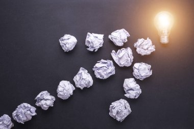 Üstten Görünüm kağıt ve ampulleri siyah taş tahta üzerinde buruşuk. CR