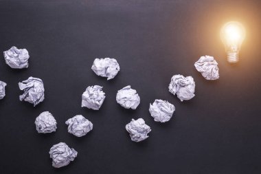Üstten Görünüm kağıt ve ampulleri siyah taş tahta üzerinde buruşuk. CR