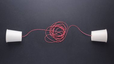 İki beyaz kağıt bardak bağlanmak için klasik telefon kullanılan kırmızı iple