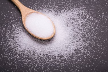 Beyaz siyah taş tablo arka plan üzerinde tahta kaşık tuz.