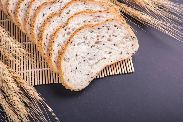 Tranches de pain blanc aux graines de sésame sur table en pierre noire bac — Photo