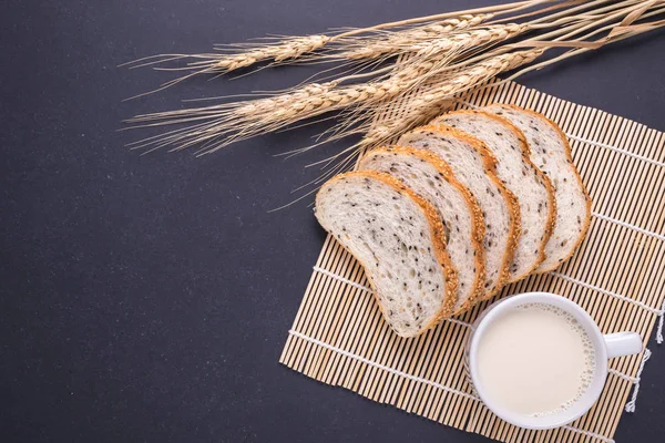 Tranches de pain blanc aux graines de sésame sur table en pierre noire bac — Photo