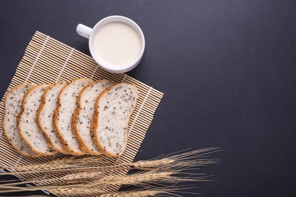 Tranches de pain blanc aux graines de sésame et lait en verre blanc — Photo