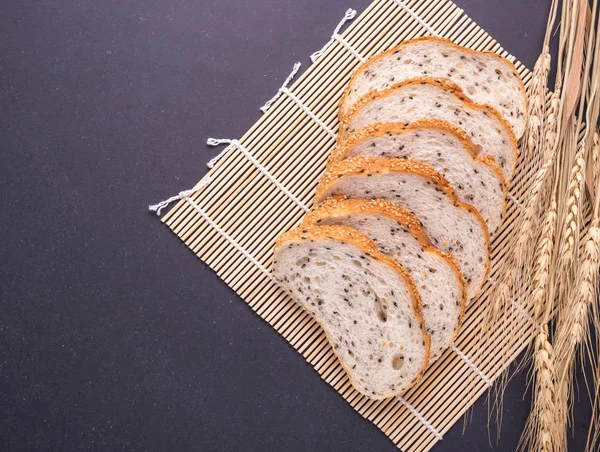Tranches de pain blanc aux graines de sésame sur table en pierre noire bac — Photo