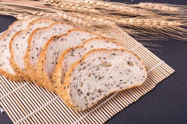 Tranches de pain blanc aux graines de sésame sur table en pierre noire bac — Photo