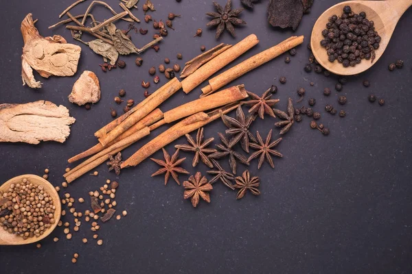 Mistura de especiarias secas e ervas na mesa de pedra preta — Fotografia de Stock