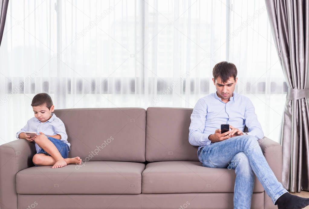 Caucasian family in status of serious. Father and son sitting on