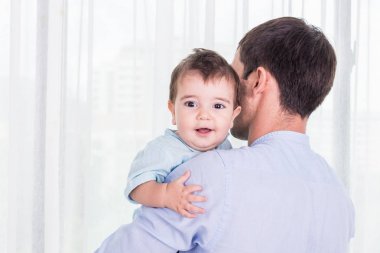 Oğlu taşıyan baba. Sağlıklı bebek omzuna gülümseyen