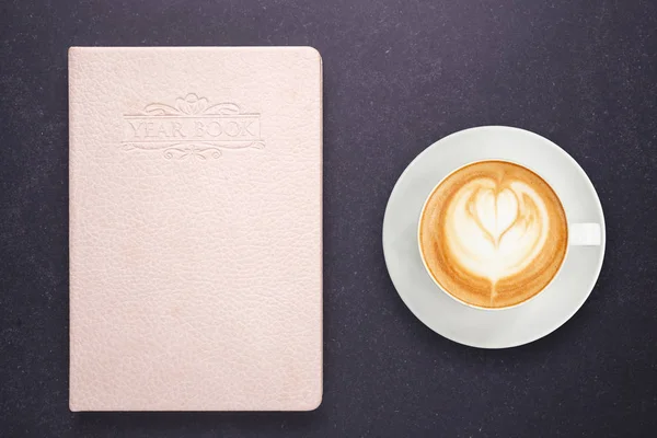 Café con leche caliente en taza blanca y cuaderno con cala vacía en blanco — Foto de Stock