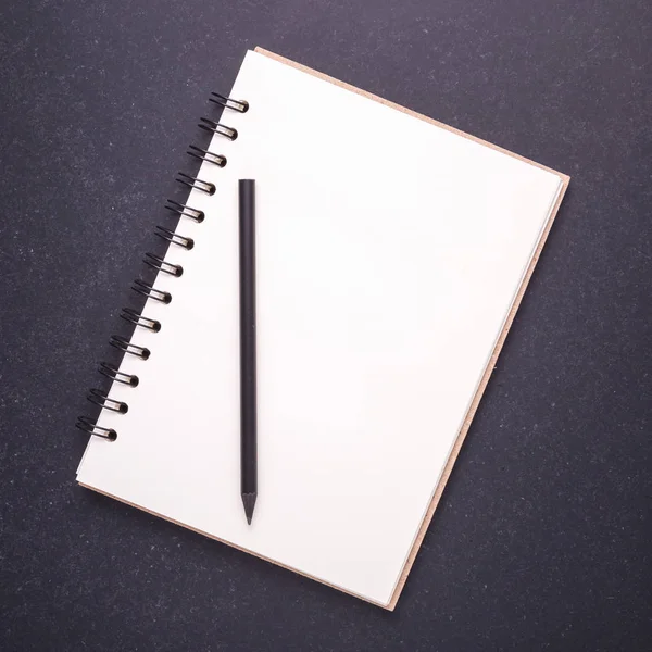 Notebook con copertina vuota vuota su sfondo tavolo di pietra nera . — Foto Stock