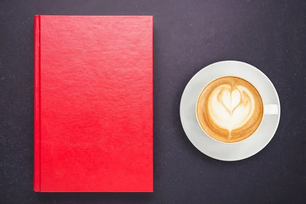 Varm latte kaffe i vit kopp och anteckningsboken med Tom Tom cove — Stockfoto