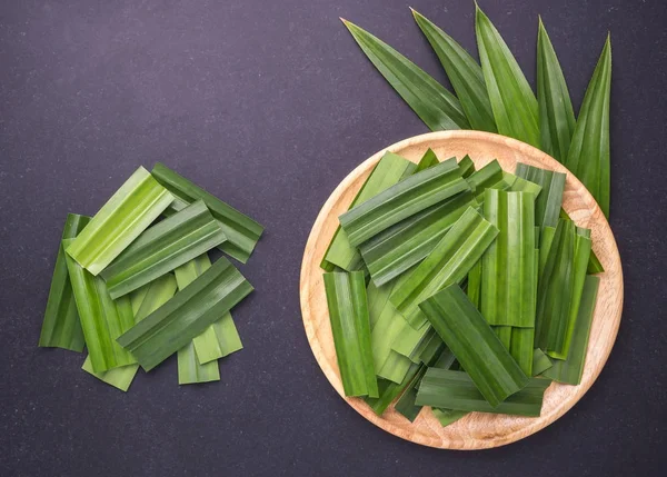 Verse groene Pandan bladeren op zwarte stenen bord. Bovenaanzicht — Stockfoto