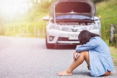 Smartphone kırık arabası önünde yolda kullanan kadın. C