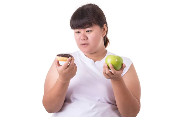 肥胖亚裔妇女佩带白色 t-shirt 并且选择吃绿色 — 图库照片